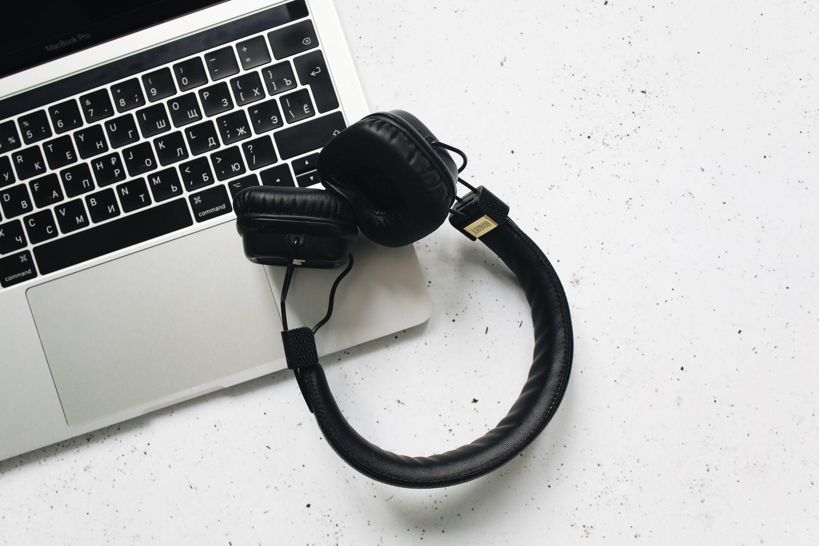Over-ear headphones resting on a laptop keyboard