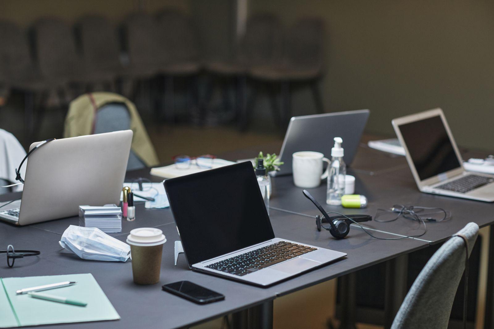Open laptops and coffee cups on a shared meeting table