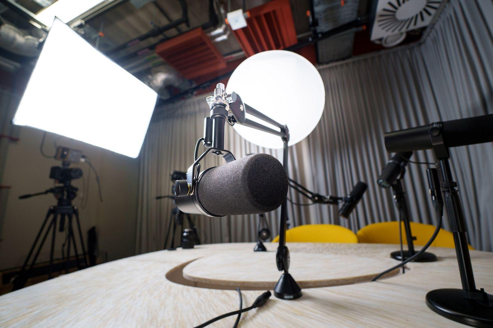Microphones on stands around a table in a recording studio