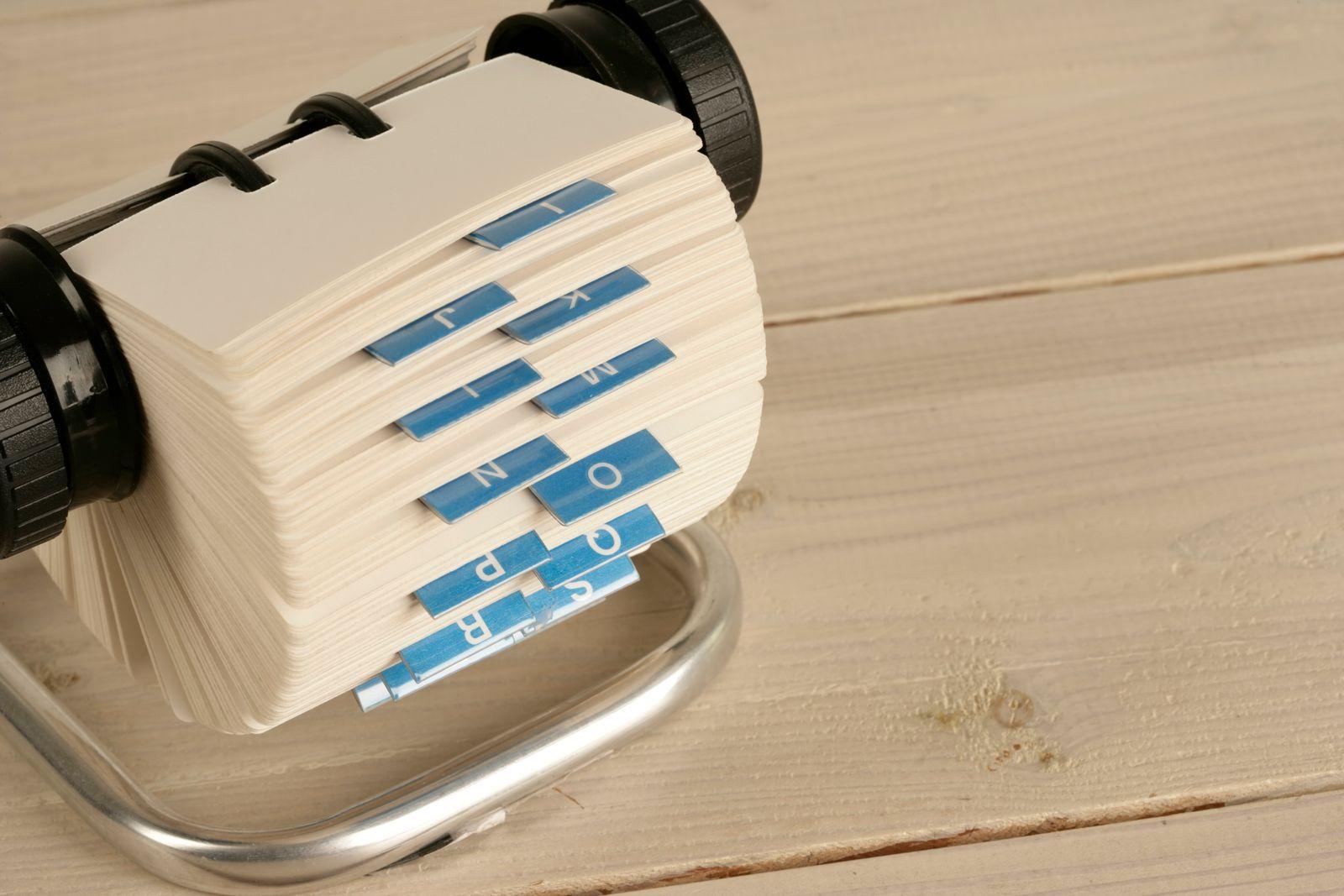 Rotary card file with lettered index tabs on a wooden desk