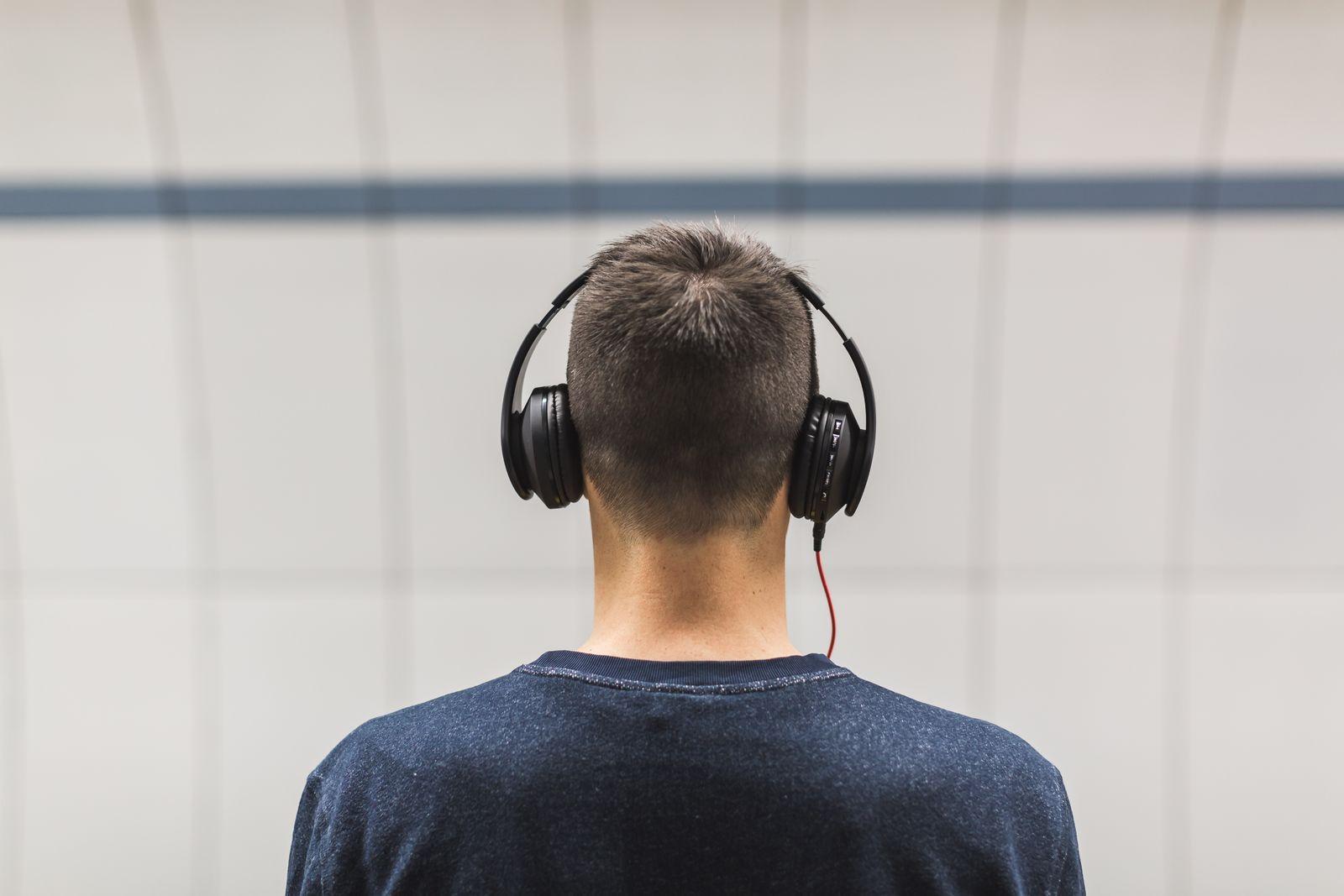 Person seen from behind wearing over-ear headphones