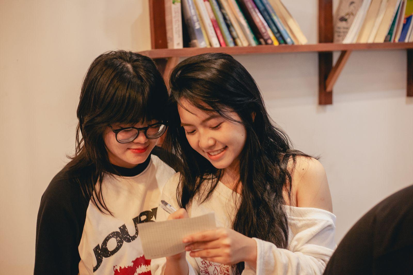 Two people smiling as they read a short handwritten note
