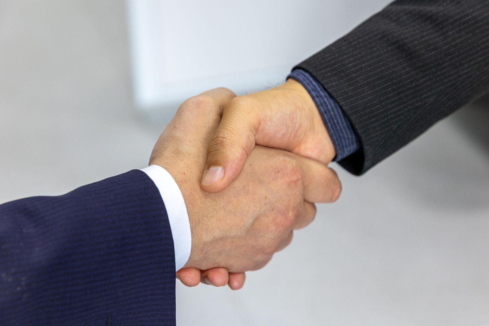 Two people in suits shaking hands