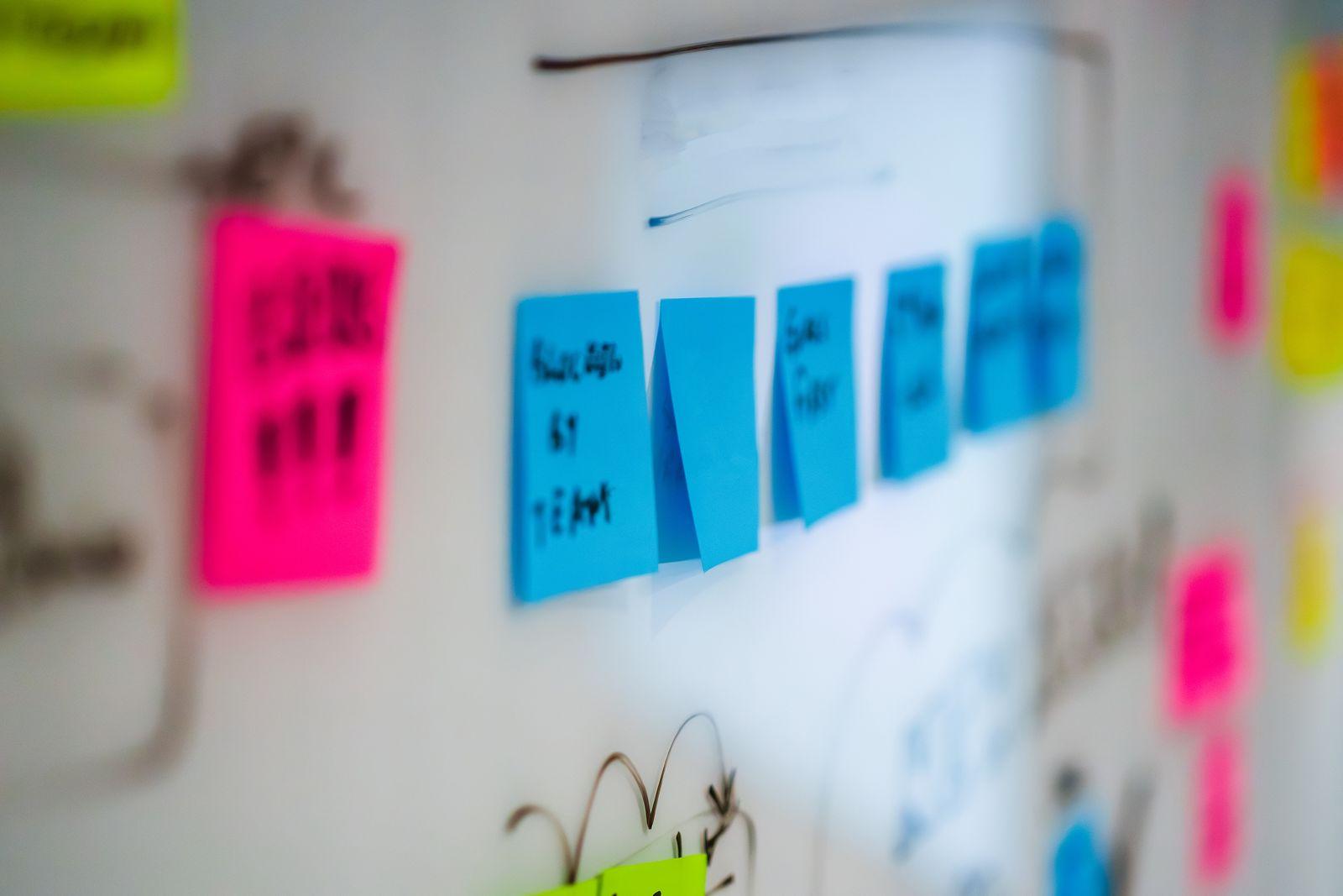 Sticky notes and handwritten notes on a whiteboard after a meeting